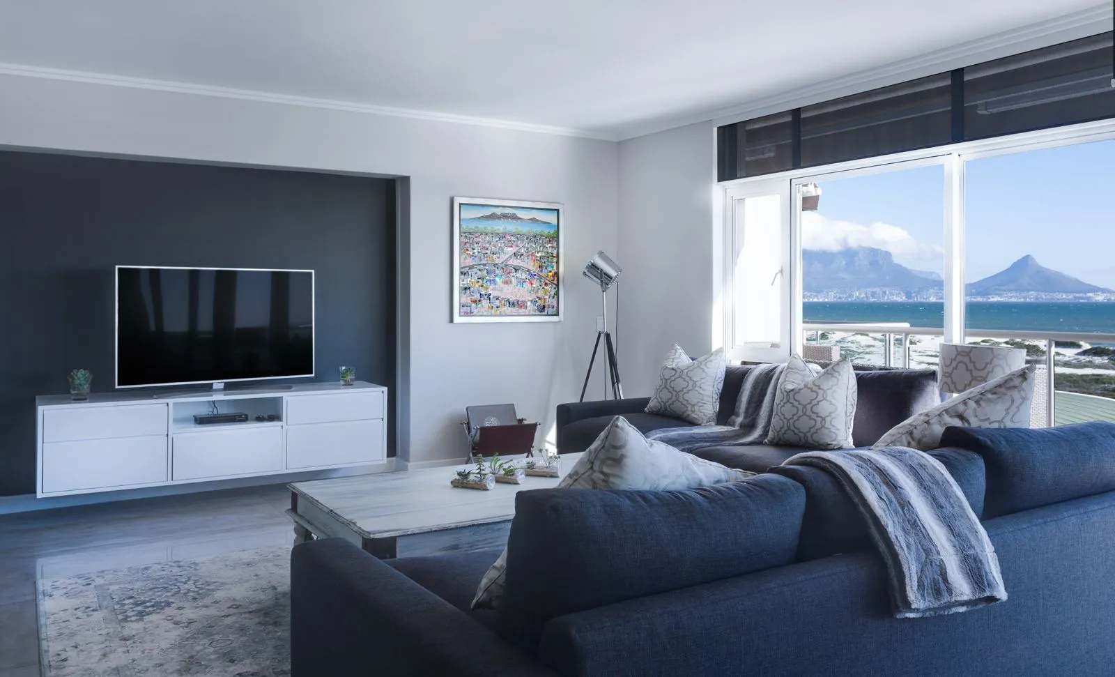 Recámara de interiorismo contemporáneo con textiles claros y lámpara de pie.